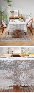 Close-up detail of white lace tablecloth showing floral embroidery and wavy scalloped edge