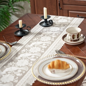 Lace table runner with magpie floral embroidery and scalloped edges on wooden table