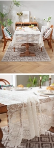 Close-up of white lace tablecloth with fine floral crochet patterns and wavy edges