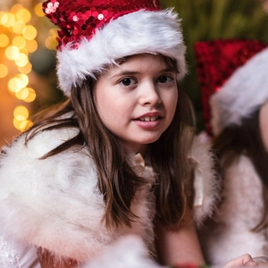 Detail of red sequined Christmas hat with fluffy white plush trim and pompom