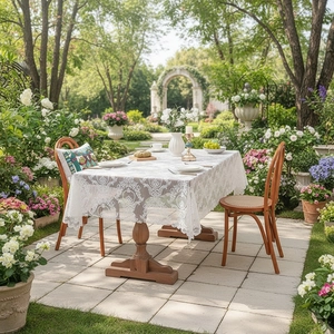 Elegant white lace tablecloth with scalloped edges on a wooden table in a garden setting