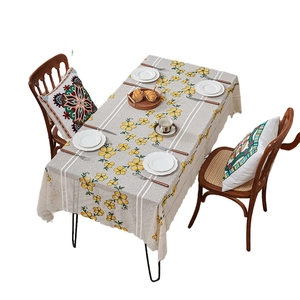 Yellow floral tablecloth with white striped lace edge on a decorated dining table