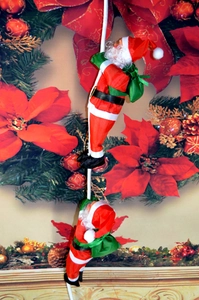 Détail de deux figurines du Père Noël grimpant sur une corde pour la décoration de Noël