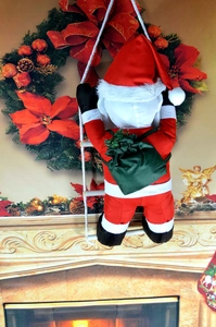 Detail of Christmas Santa Claus climbing a white rope ladder against a fireplace background