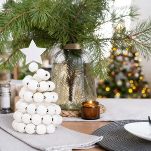 Close-up of a modern white bead Christmas tree ornament on a festive tabletop setting