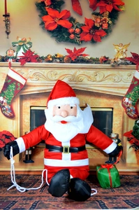 Detail of Santa Claus plush doll climbing rope with green gift box and velvet costume