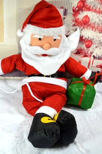 Classic plush Santa Claus ornament sitting on snow surface with green gift bag detail