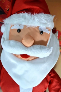 Macro close-up of Santa Claus plush doll showing detailed fabric and white felt beard