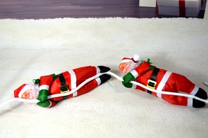 Détail de deux pères Noël grimpants sur corde blanche pour décoration murale