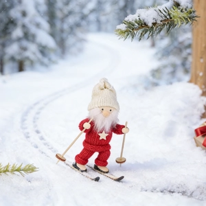 Detail of knitted Christmas gnome with wooden skis on a snowy forest background