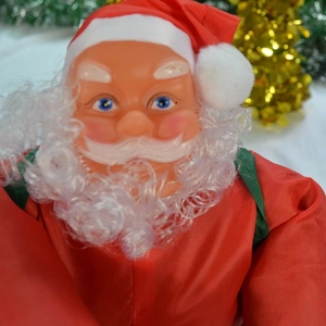 Gros plan du Père Noël avec des yeux bleus et une barbe blanche bouclée pour le sapin
