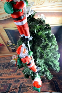 Detailed view of three Santa Claus figures climbing a 25cm white rope on a Christmas tree