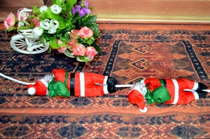 Détail de deux poupées du Père Noël grimpant sur corde pour décoration murale festive