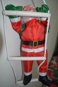 Dettaglio di Babbo Natale che sale una scala di corda bianca per decorazioni festive