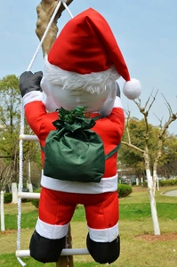 Detail of Santa Claus climbing a white rope ladder with a green gift bag on his back