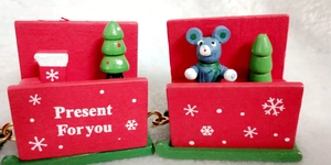 Close-up of red and green wooden Christmas train wagons with trees and small bear figurines
