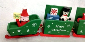 Detailed view of red and green wooden Christmas train with Santa and Snowman figurines