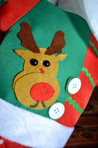 Detail of Christmas reindeer decoration with red nose, felt fabric, and white buttons