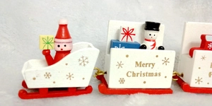 Close-up of red wooden Christmas train with Santa Claus, snowmen and Merry Christmas prints