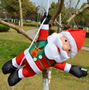 Detail of climbing Santa Claus ornament on white rope with reindeer vest on tree branch