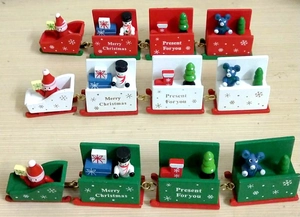 Detail of wooden Christmas train sets featuring Santa, snowmen, and hand-painted motifs