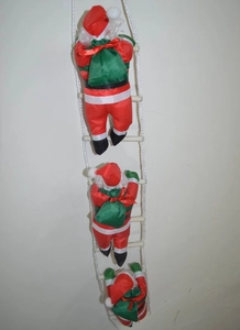 Three plush Santa Claus figures climbing a white rope ladder for holiday wall decor
