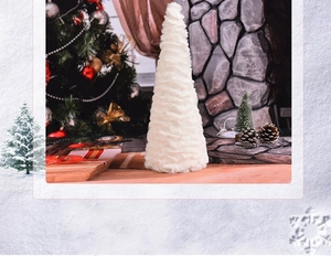 Close-up of white plush Christmas tree decoration on wood tabletop with festive background