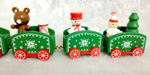 Detail view of green wooden Christmas train with festive snowmen and gift decorations