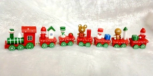 Detail of wooden 7-section Christmas train with Santa and snowman figures on snow background