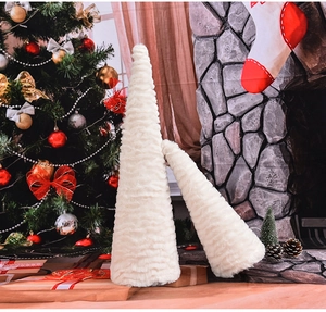Detail of white fluffy cone Christmas trees with soft textured plush on a festive table