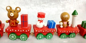 Detail view of a 7-section wooden Christmas train with a snowman and gingerbread man decor