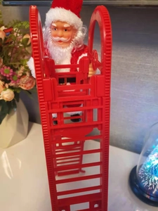 Vue détaillée du Père Noël électrique grimpant sur une échelle rouge en plastique