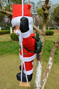 Detail of hanging Santa Claus figure climbing a rope ladder for outdoor Christmas decor
