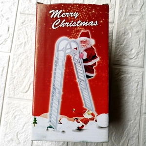Boîte cadeau de Noël rouge illustrant le Père Noël électrique grimpant sur une échelle