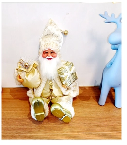 Detail view of a white and gold plush Santa figure holding a gift box and gold sack