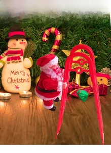 Detail showing an electric Santa Claus toy climbing a red ladder with a gift bag