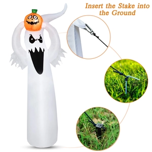 Macro view of inflatable ghost holding pumpkin with stakes and ropes for windproof setup