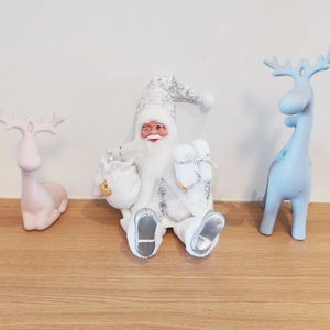 Seated plush Santa Claus with silver sequins and colorful decorative resin reindeer