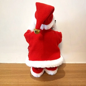 Rear view of a classic red plush Santa Claus figurine with white fur trim and golden bell