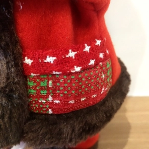 Detailed texture of electric Santa Claus doll with red felt fabric and faux fur trim