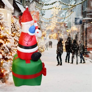 Close-up of 1.8m inflatable Santa Claus sitting on a green gift box for outdoor decor