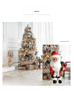 Detail of electric dancing Santa Claus figure standing next to a decorated Christmas tree