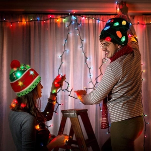 Detail of colorful LED glowing knitted Christmas hats with festive holiday patterns
