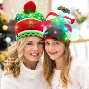 Detail of LED glowing knitted Christmas hats with pom-poms on adult and child models