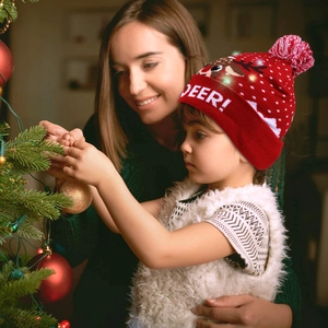 Close-up of LED Christmas hat with glowing reindeer pattern and festive deer text