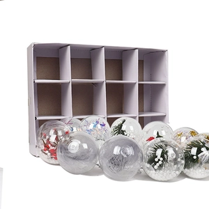 Detail of 12 clear plastic Christmas balls with pine needles and berries in a storage box