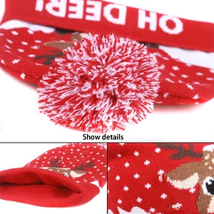 Detail of red knitted Christmas hat with reindeer pattern and pom-pom textures
