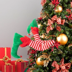 Detail of plush Christmas elf legs with striped stockings and green boots on a Xmas tree
