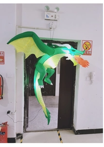 Detail of inflatable green dragon with integrated LED lights and orange flame mouth