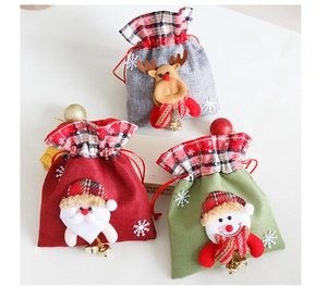 Close-up of Christmas linen gift bags with reindeer, Santa, snowman and gold bells